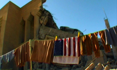 Flag on clothesline against a ruined building in the background.